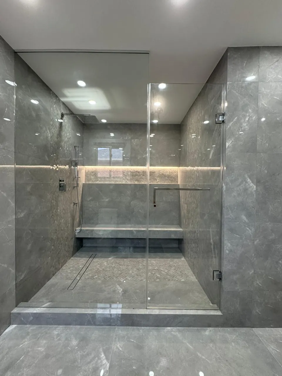 Walk-in shower with built-in bench and LED strip lighting