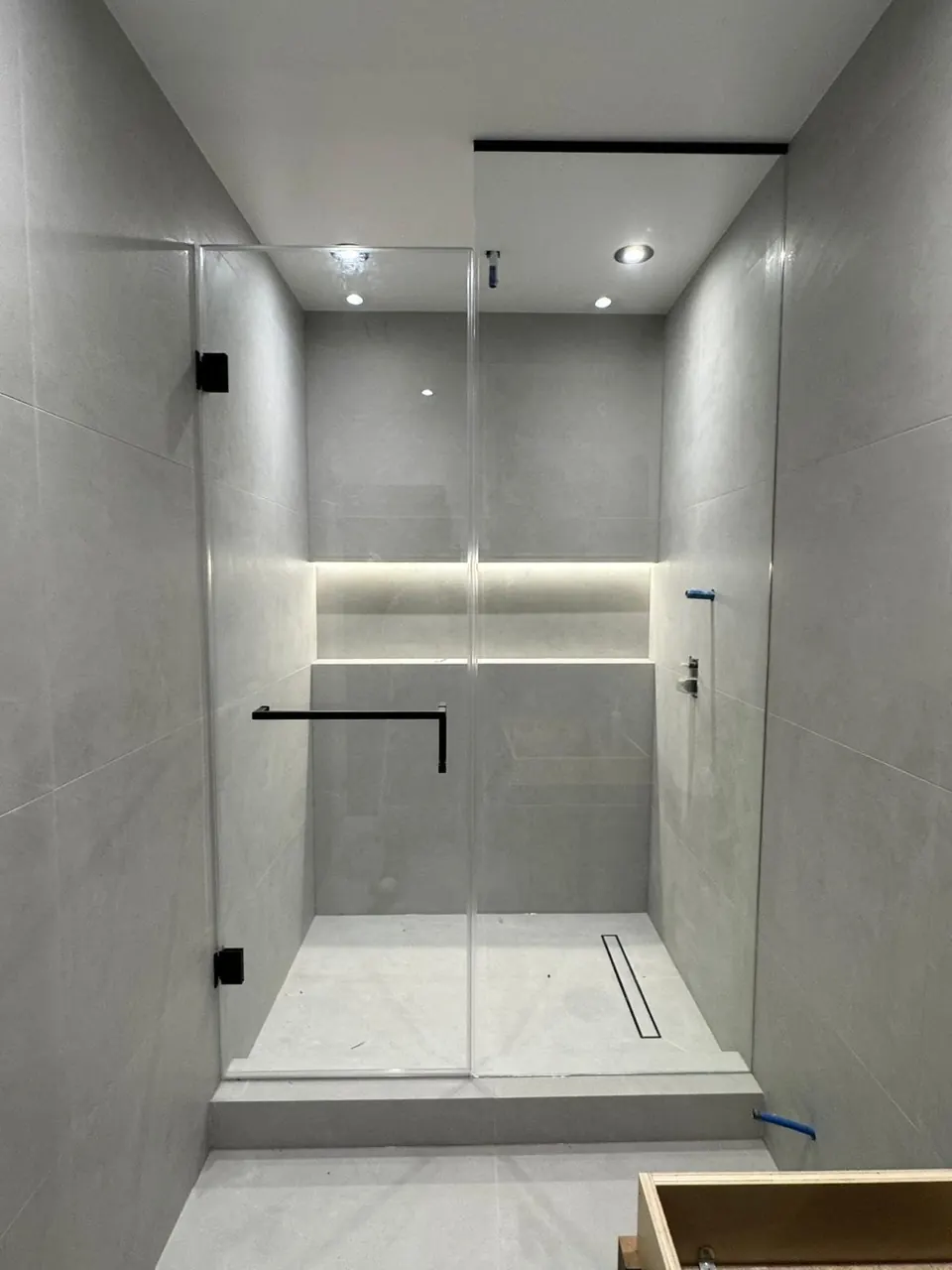 Walk-in shower with lit niche and black hardware